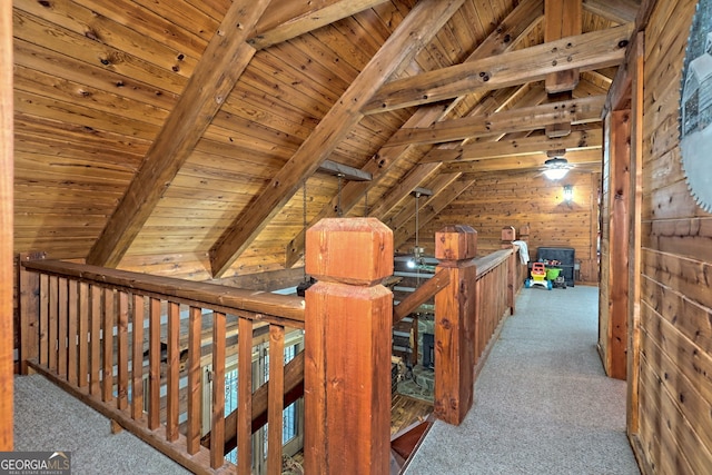 hall featuring lofted ceiling with beams, wooden ceiling, and carpet flooring