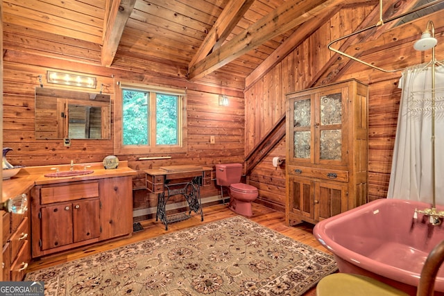 bathroom with wooden walls, lofted ceiling with beams, wooden ceiling, toilet, and wood finished floors