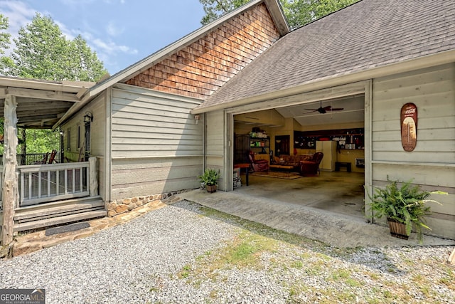 view of side of home with a garage, gravel driveway, and roof with shingles