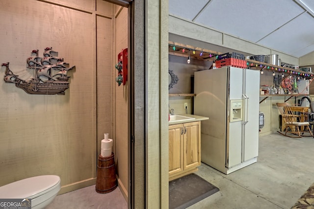 interior space featuring toilet, unfinished concrete flooring, and vanity