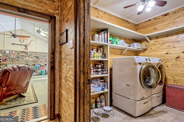 washroom featuring laundry area, washing machine and dryer, wooden walls, and a ceiling fan