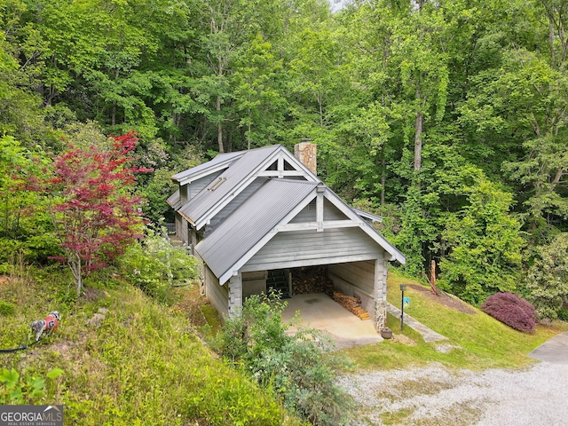 exterior space featuring driveway and a forest view