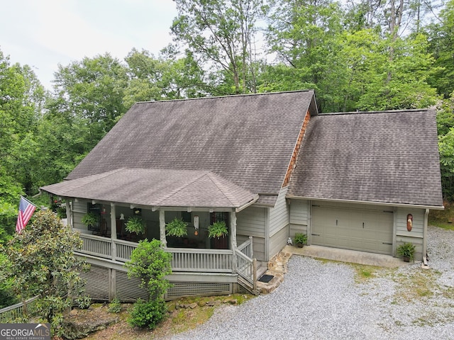 view of front of home with driveway, a porch, an attached garage, and a shingled roof