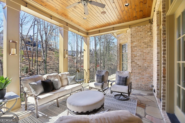 sunroom / solarium with wood ceiling and a ceiling fan