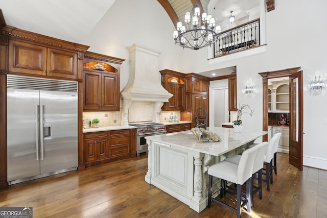 440 Belada Blvd, Sandy Springs, GA 30342 - kitchen with high quality appliances, custom exhaust hood, a chandelier, high vaulted ceiling, and dark wood-style floors