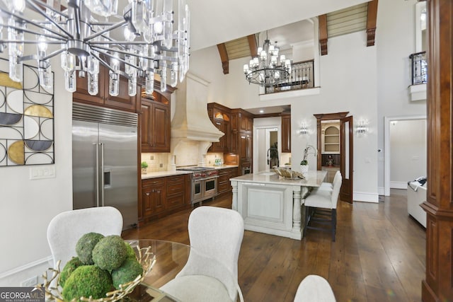 440 Belada Blvd, Sandy Springs, GA 30342 - kitchen with high quality appliances, a chandelier, custom exhaust hood, light countertops, and a towering ceiling