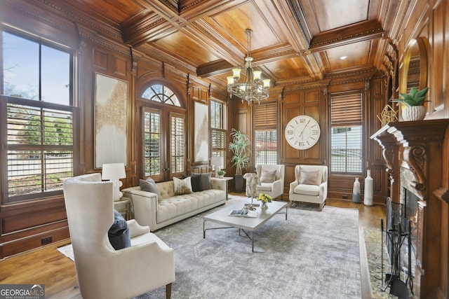 living room with ornamental molding, wood ceiling, wooden walls, and french doors