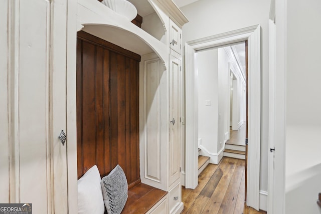 mudroom with light wood-type flooring and arched walkways