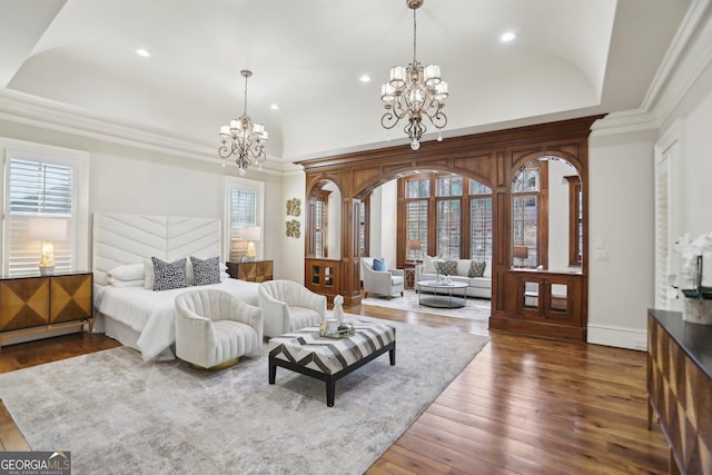 bedroom with ornamental molding, hardwood / wood-style floors, a tray ceiling, a chandelier, and recessed lighting