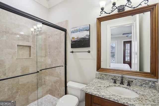 bathroom with toilet, an inviting chandelier, a stall shower, vanity, and ensuite bath