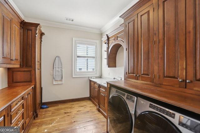 440 Belada Blvd, Sandy Springs, GA 30342 - washroom featuring separate washer and dryer, cabinet space, light wood-type flooring, and ornamental molding