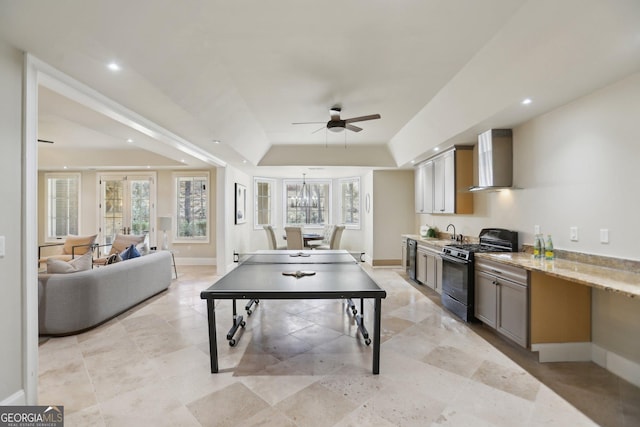 game room with baseboards, a tray ceiling, a sink, and recessed lighting