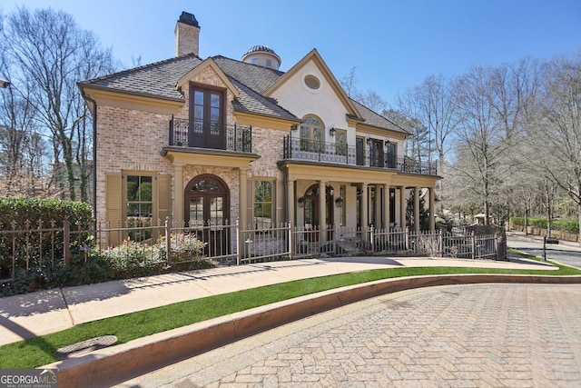 440 Belada Blvd, Sandy Springs, GA 30342 - french country inspired facade featuring a balcony, french doors, brick siding, a chimney, and a porch