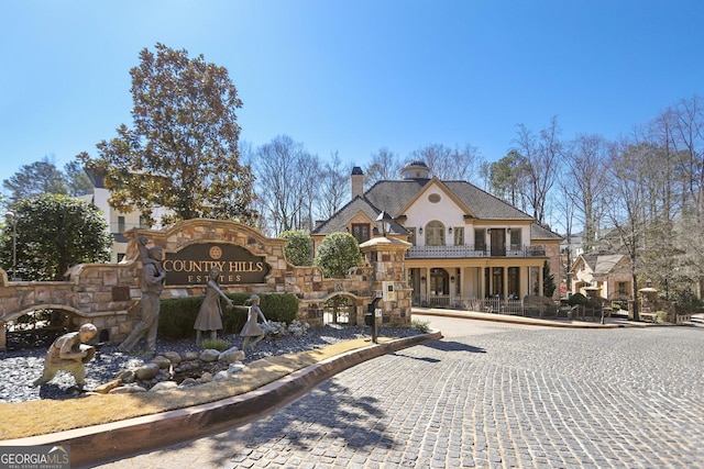 view of front of house with stone siding and a chimney