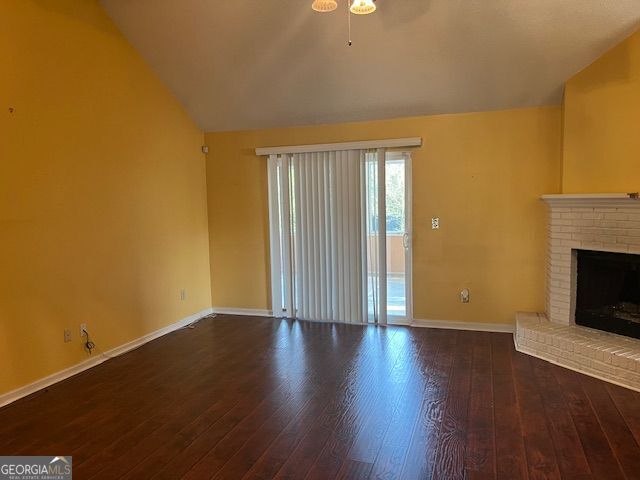 355 Tait Rd, Stockbridge, GA 30281 - unfurnished living room with lofted ceiling, baseboards, ceiling fan, wood finished floors, and a fireplace