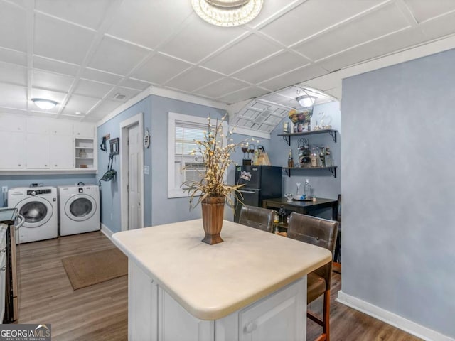 kitchen featuring dark wood-style flooring, washer and clothes dryer, open shelves, freestanding refrigerator, and white cabinetry