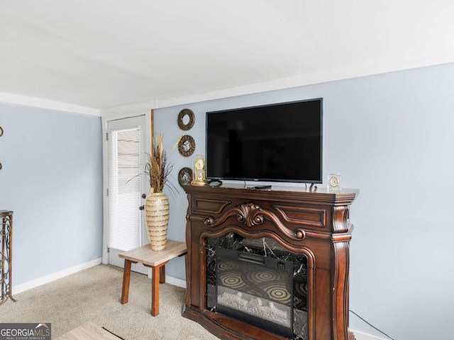 living area featuring baseboards and light colored carpet