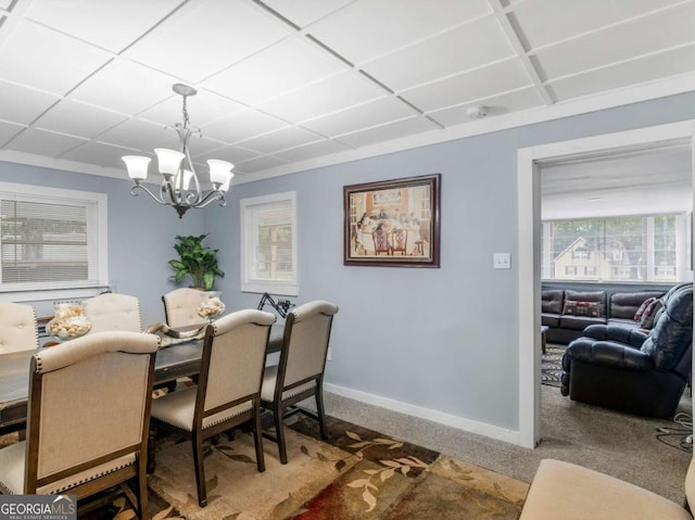 carpeted dining area with baseboards and an inviting chandelier