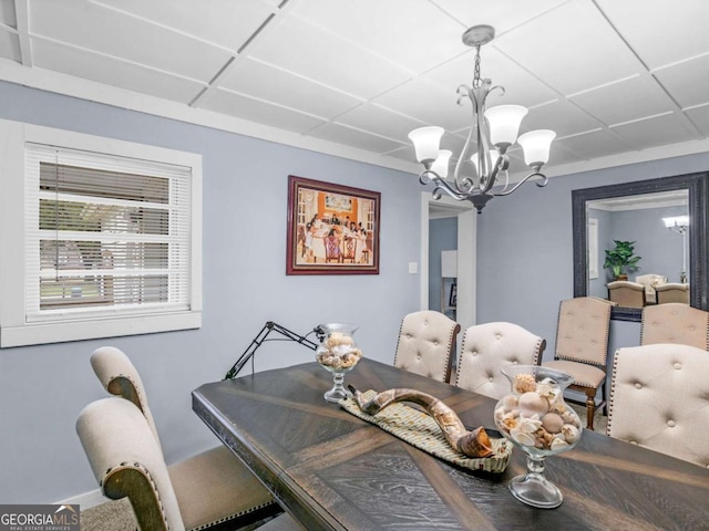 dining area with a chandelier and a drop ceiling