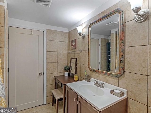 bathroom with visible vents, vanity, tile walls, and tile patterned floors