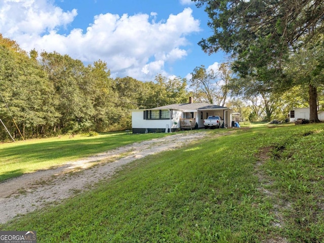 view of front facade featuring a carport, driveway, and a front lawn