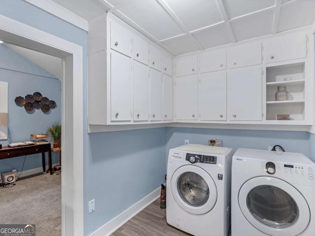 washroom featuring washer and clothes dryer, cabinet space, and baseboards