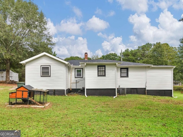 rear view of house with central AC, a yard, a shingled roof, and a chimney