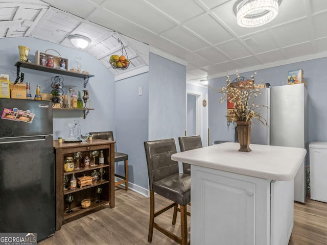 dining room with a drop ceiling and light wood finished floors