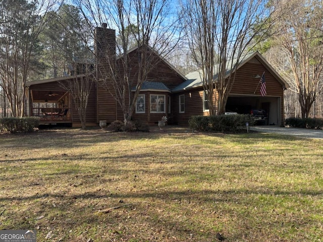 view of front of property with a garage, a chimney, and a front yard