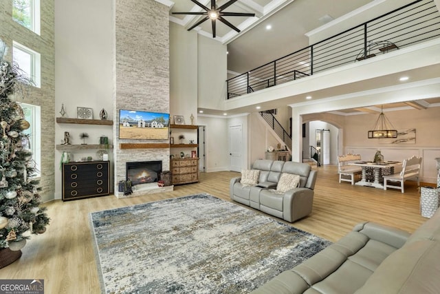2634 Greenes Ln, Powder Springs, GA 30127 - living room featuring wood finished floors, a fireplace, arched walkways, stairs, and a towering ceiling