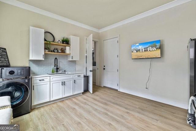 2634 Greenes Ln, Powder Springs, GA 30127 - washroom featuring washer / dryer, light wood-style flooring, cabinet space, a sink, and crown molding
