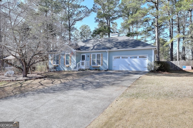 ranch-style home with a garage, driveway, and fence