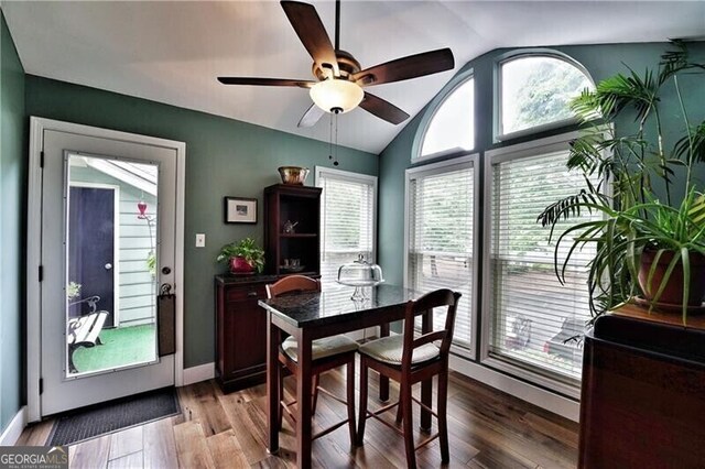 dining area featuring lofted ceiling, a ceiling fan, baseboards, and wood finished floors