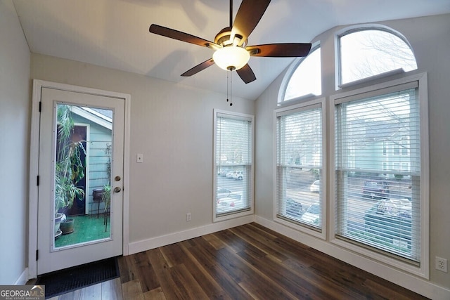 doorway featuring dark wood-style floors, ceiling fan, lofted ceiling, and baseboards