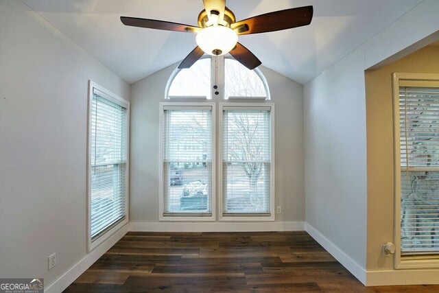 interior space featuring vaulted ceiling, ceiling fan, dark wood-style flooring, and baseboards