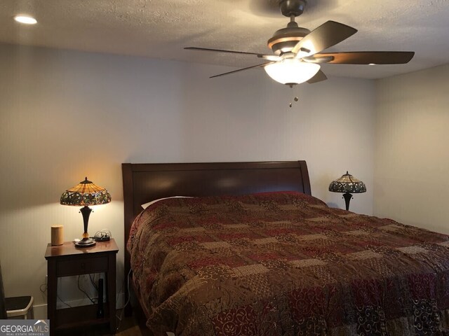 bedroom with a textured ceiling and a ceiling fan