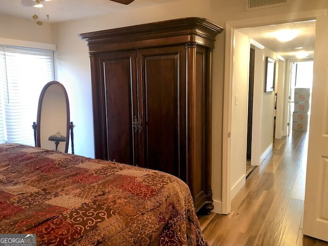 bedroom featuring light wood-type flooring, visible vents, and baseboards