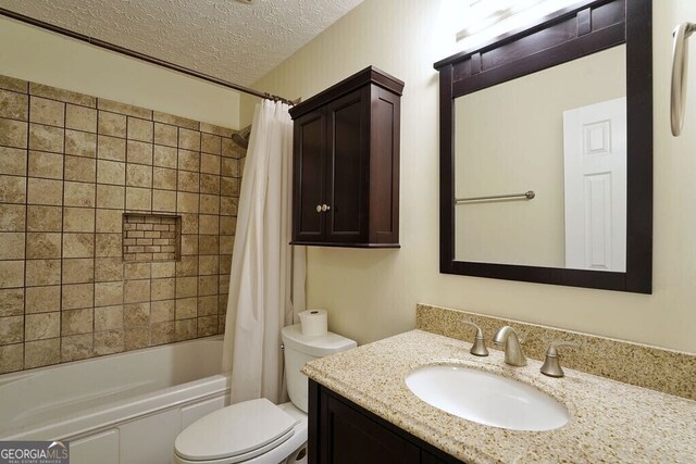 bathroom featuring a textured ceiling, toilet, vanity, and shower / tub combo with curtain