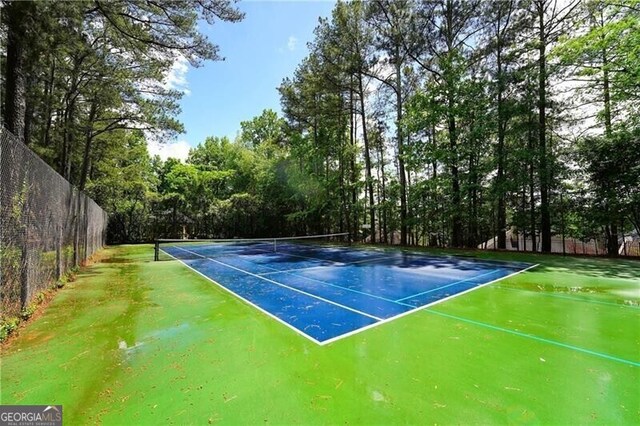 view of tennis court featuring fence