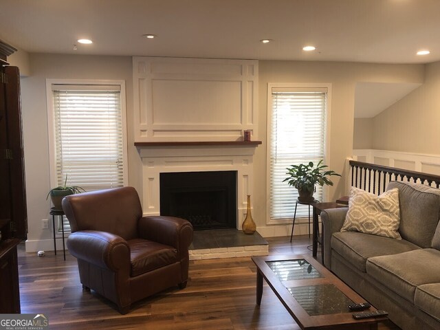 living room with dark wood-style floors, baseboards, a large fireplace, and recessed lighting