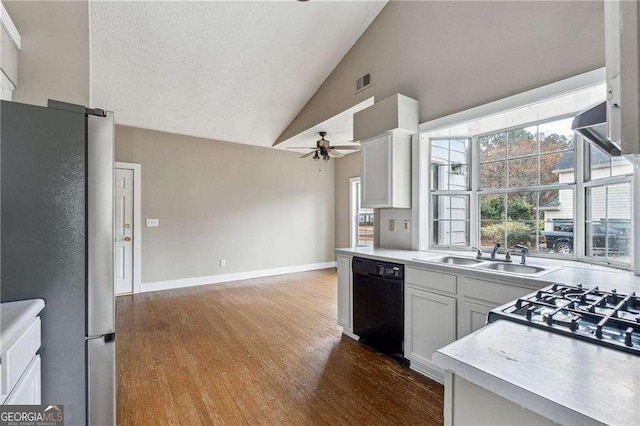 kitchen featuring dishwasher, freestanding refrigerator, light countertops, white cabinetry, and a sink