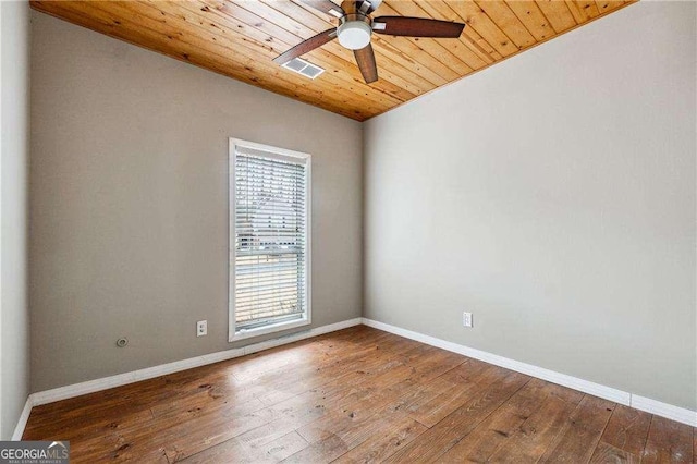 unfurnished room with wooden ceiling, baseboards, visible vents, and wood finished floors