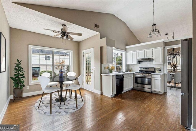 kitchen featuring visible vents, light countertops, hanging light fixtures, appliances with stainless steel finishes, and under cabinet range hood