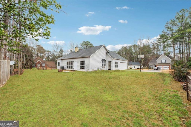 exterior space featuring a chimney, fence, and a lawn