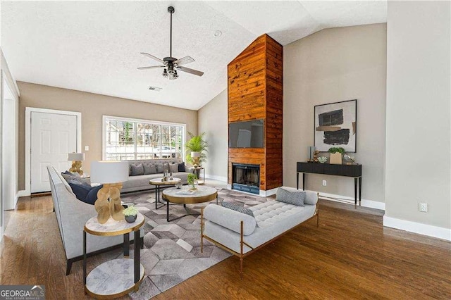 living room featuring a large fireplace, a ceiling fan, baseboards, and wood finished floors