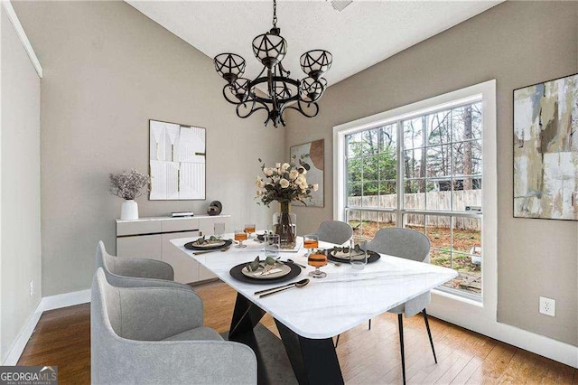 dining room featuring a chandelier, wood finished floors, and baseboards