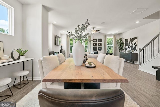 dining area featuring light wood-style flooring, stairway, baseboards, and recessed lighting