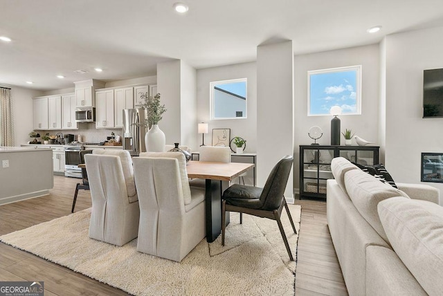 dining space featuring baseboards, recessed lighting, and light wood-style floors