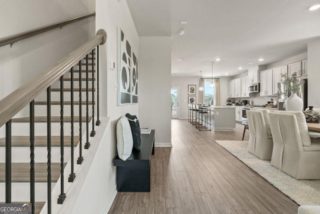 interior space with baseboards, wood finished floors, and recessed lighting