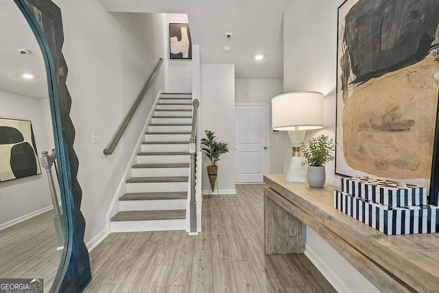 stairs with wood finished floors and baseboards